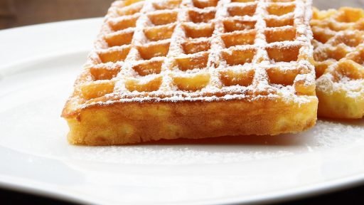 Goudbruine garnaalkroketten op een bord met mayonaise en een schijfje citroen