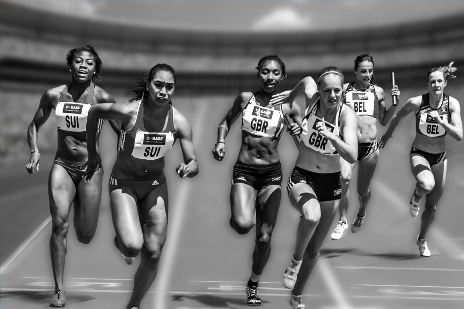 Vrouwelijke atletes vieren een overwinning op de atletiekbaan