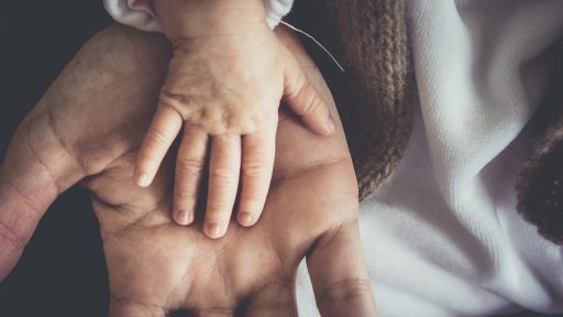 Ouder overhandigt sleutel aan kind bij aankoop woning