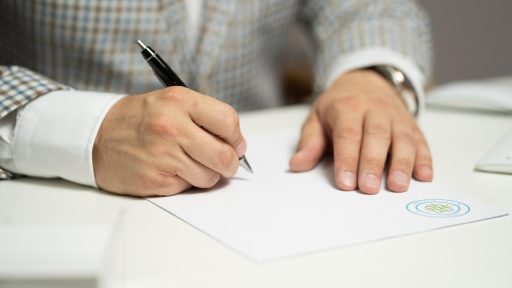 Notaris die documenten ondertekent aan een bureau tijdens een vermogensverdeling