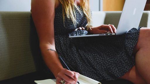 Vrouw werkt geconcentreerd aan haar bureau thuis, symbolisch voor de combinatie van professioneel leven en gezinstaken