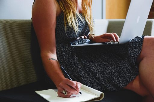 Vrouw werkt geconcentreerd aan haar bureau thuis, symbolisch voor de combinatie van professioneel leven en gezinstaken