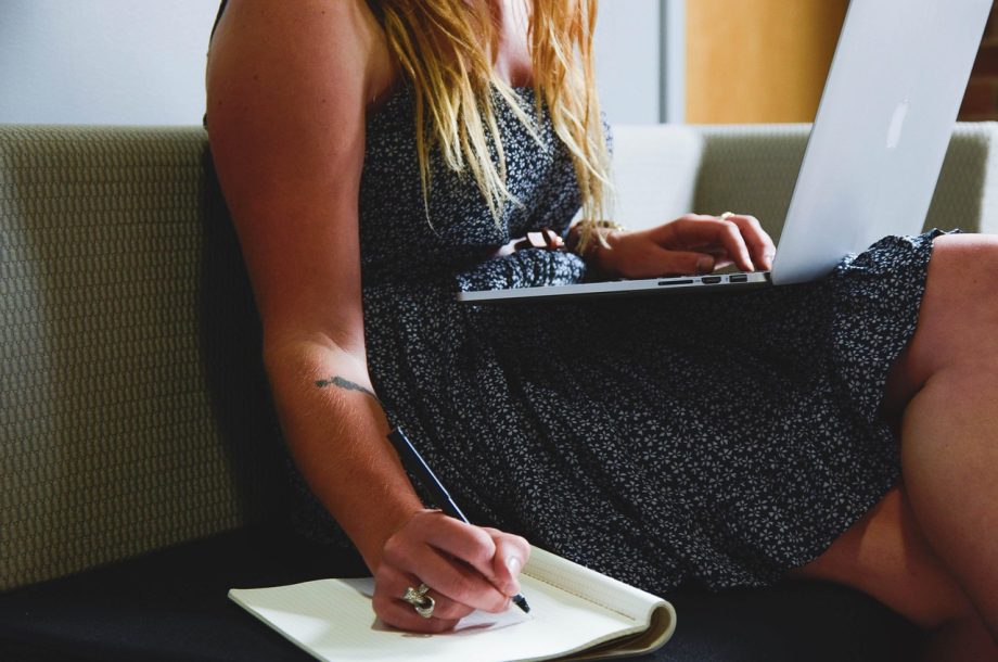 Vrouw werkt geconcentreerd aan haar bureau thuis, symbolisch voor de combinatie van professioneel leven en gezinstaken