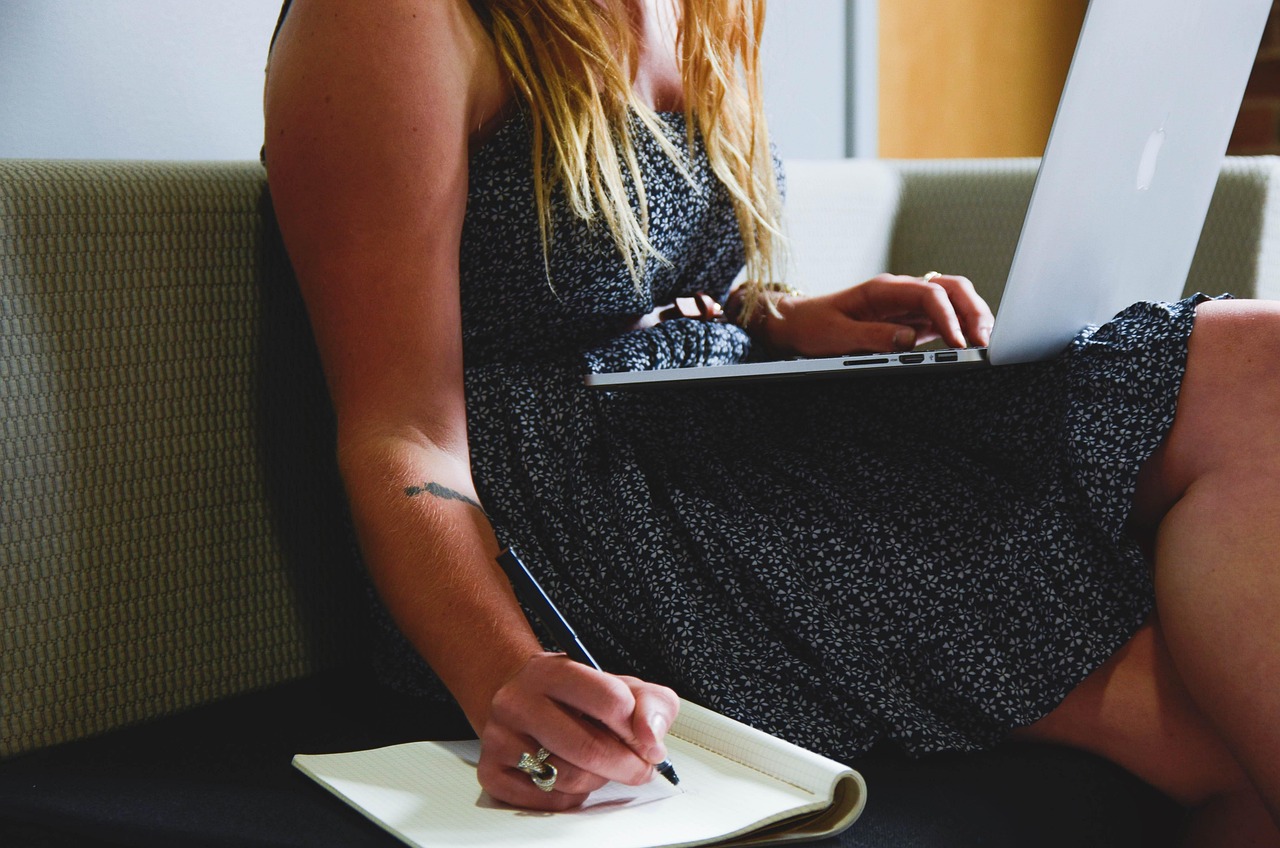 Vrouw werkt geconcentreerd aan haar bureau thuis, symbolisch voor de combinatie van professioneel leven en gezinstaken